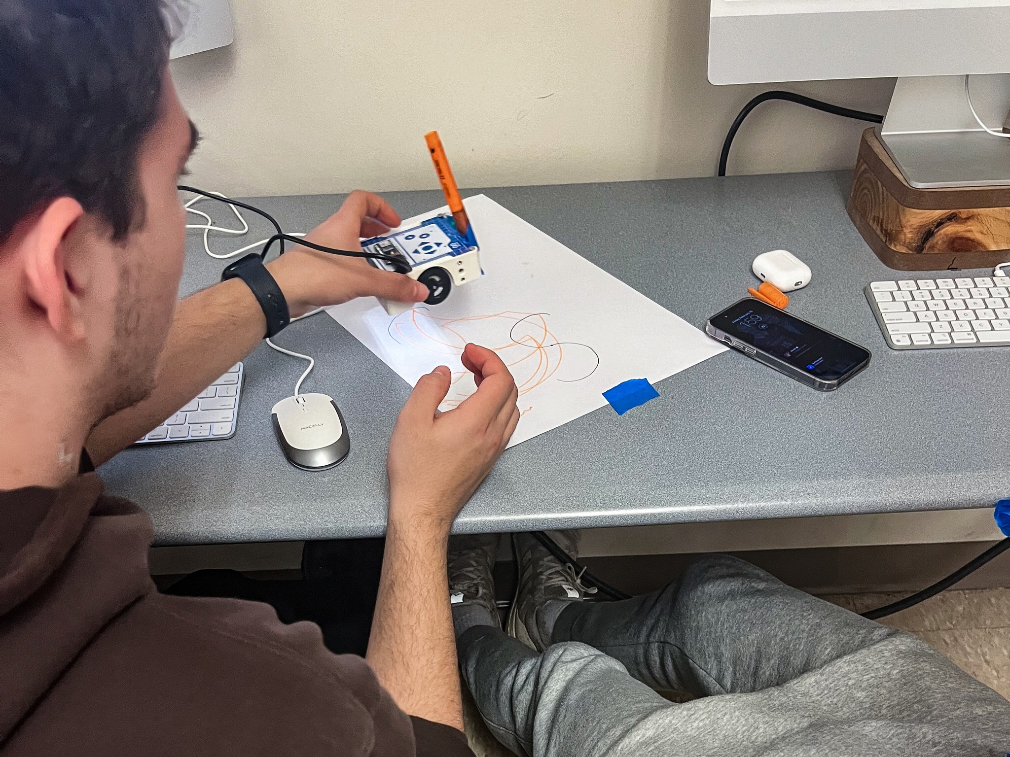Close-up of a student using the Arduino Alvik robot car to create drawings during usability testing session – Liam Aljundi